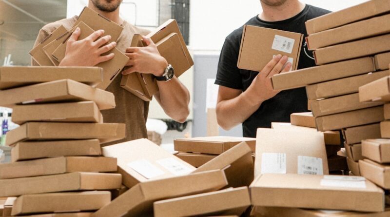 a couple of men standing next to a pile of boxes